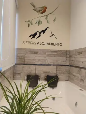 a bathroom with a tub and a bird on a sign at Apart Deluxe in Mina Clavero
