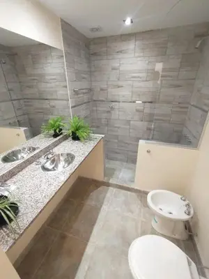 a bathroom with two sinks and a toilet at Apart Deluxe in Mina Clavero