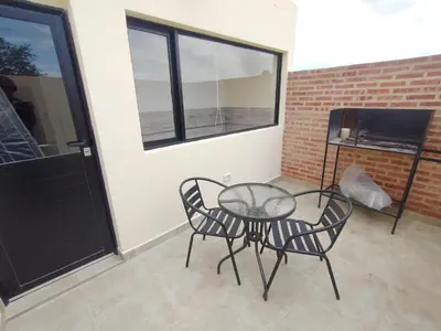 a patio with a table and two chairs and a television at Apart Deluxe in Mina Clavero