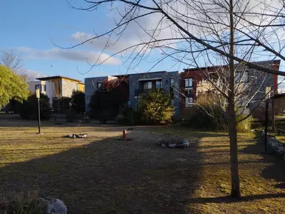 a yard with a tree and buildings in the background at Paraíso Serrano 19 in Los Reartes