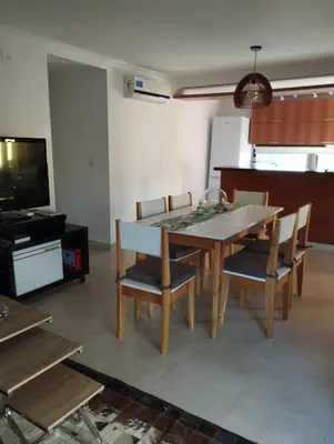 a dining room with a table and chairs and a television at Paraíso Serrano 19 in Los Reartes