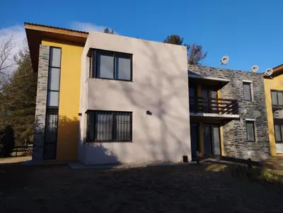 a white and yellow house with a shadow at Paraíso Serrano 19 in Los Reartes
