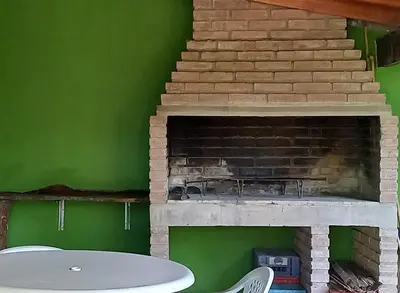 a living room with a fireplace with a green wall at Casa Icho Cruz in Villa Icho Cruz