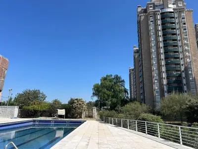 a swimming pool with two tall buildings in the background at Excepcional departamento en Piso 18 en zona norte de Córdoba capital con una vista inigualable en barrio privado Alto Villa Sol in Cordoba