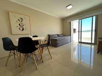 a living room with a table and chairs and a couch at Excepcional departamento en Piso 18 en zona norte de Córdoba capital con una vista inigualable en barrio privado Alto Villa Sol in Cordoba