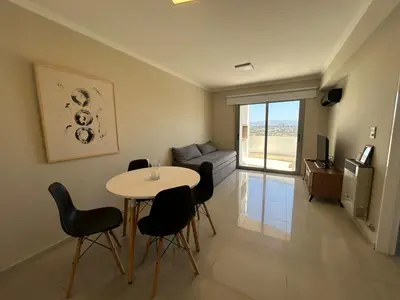 a living room with a table and chairs and a couch at Excepcional departamento en Piso 18 en zona norte de Córdoba capital con una vista inigualable en barrio privado Alto Villa Sol in Cordoba