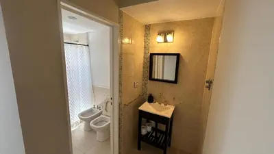 a bathroom with a toilet and a sink and a mirror at Excepcional departamento en Piso 18 en zona norte de Córdoba capital con una vista inigualable en barrio privado Alto Villa Sol in Cordoba