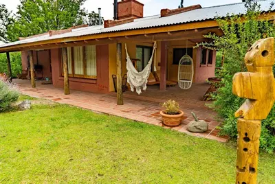 a house with a front porch with a swing at Magenta Complejo Cabañas & Spa in San Javier