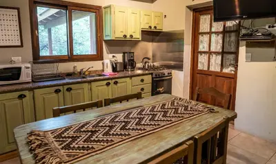 a kitchen with a table with a pattern on it at Magenta Complejo Cabañas & Spa in San Javier