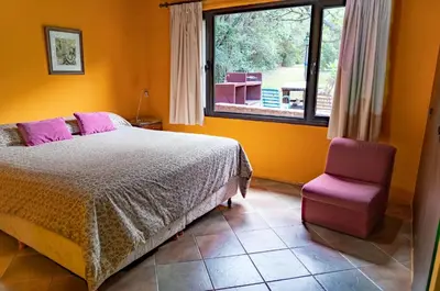 a bedroom with a bed and a chair and a window at Magenta Complejo Cabañas & Spa in San Javier
