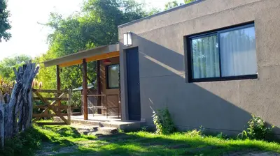 a house with a wooden door and a fence at Magenta Complejo Cabañas & Spa in San Javier