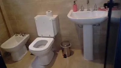 a bathroom with a toilet and a sink at Magenta Complejo Cabañas & Spa in San Javier