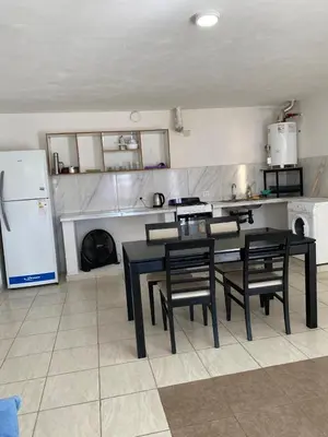 a kitchen with a table and chairs and a refrigerator at Depto por día in Río Cuarto