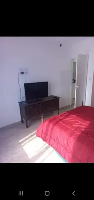 a bedroom with a bed and a desk with a television at Depto por día in Río Cuarto