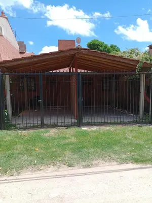 a metal gate in front of a house at Suites de Montaña Despertar del Gallo in Villa Cura Brochero