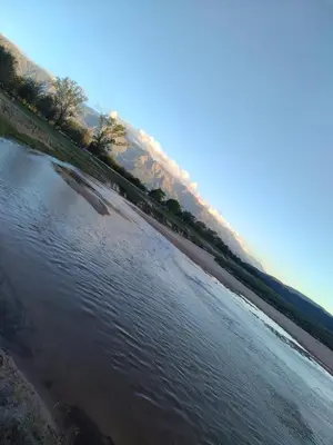 a body of water with trees and a beach at Suites de Montaña Despertar del Gallo in Villa Cura Brochero