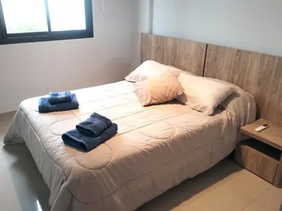 a bed with two blue towels sitting on it at Depto 1 dormitorio totalmente equipado in Cordoba