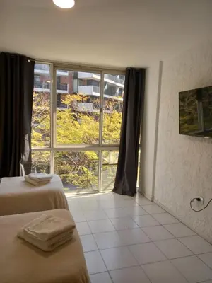 a hotel room with two beds and a large window at Apartamento Nueva Cordoba in Cordoba
