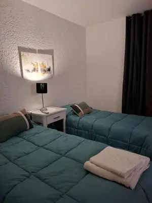 a room with two beds and a table with a lamp at Apartamento Nueva Cordoba in Cordoba