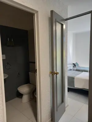 a bathroom with a toilet and a bed at Apartamento Nueva Cordoba in Cordoba