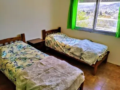 two beds in a room with a window at Shakespeare 176 Ph3 in Villa Carlos Paz