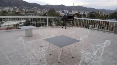 a patio with white chairs and a table on a balcony at Shakespeare 176 Ph3 in Villa Carlos Paz