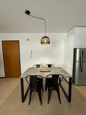 a kitchen with a table with chairs and a refrigerator at Departamento Remodelado en Nva in Cordoba