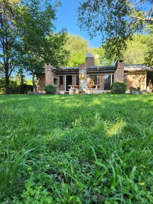 a brick house in a field of green grass at El descanso in Villa Ciudad Parque