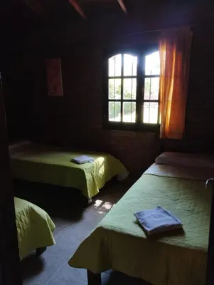 a room with three beds and a window at El descanso in Villa Ciudad Parque