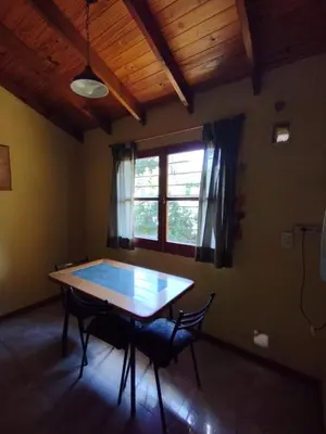 a dining room with a table and chairs and a window at El descanso in Villa Ciudad Parque
