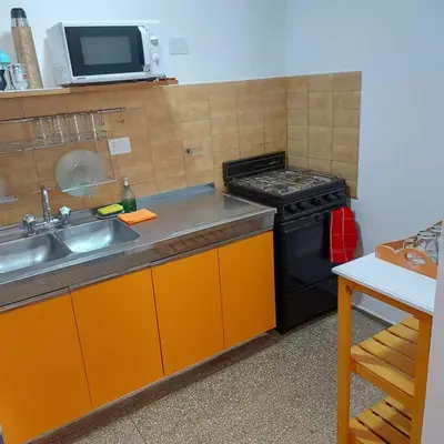 a kitchen with a stove and a sink and a microwave at Microcentro de la Docta in Cordoba