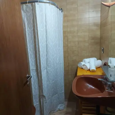 a bathroom with a sink and a shower with towels at Microcentro de la Docta in Cordoba