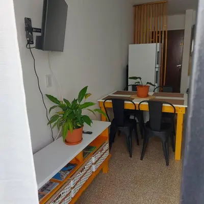 a room with a table and chairs and a tv at Microcentro de la Docta in Cordoba