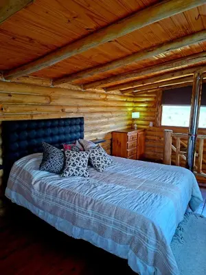 a bedroom with a bed in a log cabin at La Autóctona in Villa Yacanto