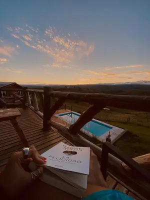 a person sitting on a deck with a book at La Autóctona in Villa Yacanto