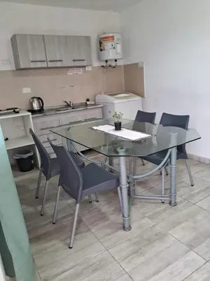a kitchen with a table and chairs in a kitchen at pepesapart in Cordoba