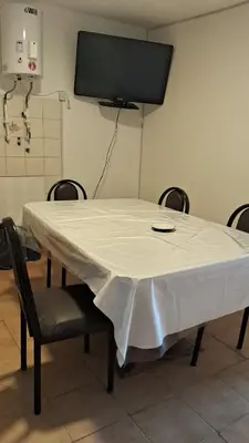 a white table with chairs and a tv on the wall at pepesapart in Cordoba