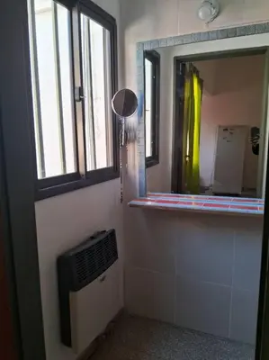 a bathroom with a mirror on the wall and a window at comodidad y tranquilidad in Cordoba