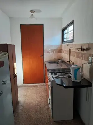 a kitchen with a stove and a brown door at comodidad y tranquilidad in Cordoba