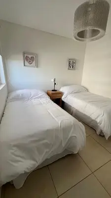 two beds with white sheets in a room at Confort y seguridad in Cordoba