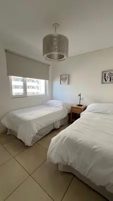a bedroom with two beds and a chandelier at Confort y seguridad in Cordoba