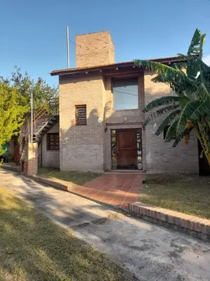 an old brick house with a door on a street at Depto Granja de Funes in Cordoba