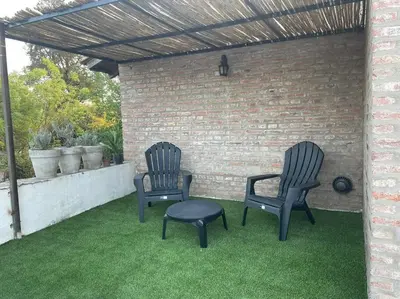 two chairs and a ottoman sitting on a patio at Depto Granja de Funes in Cordoba