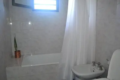 a bathroom with a tub and a toilet and a sink at Depto Granja de Funes in Cordoba