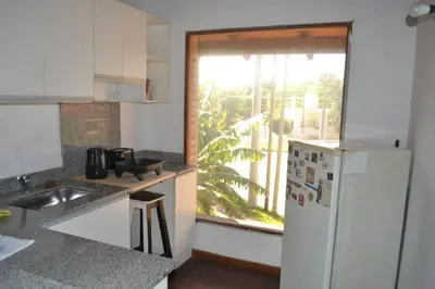 a kitchen with a white refrigerator and a window at Depto Granja de Funes in Cordoba