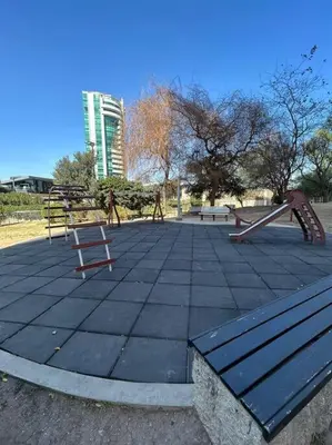 a park with a playground with swings and a bench at Depto Villa Sol in Cordoba