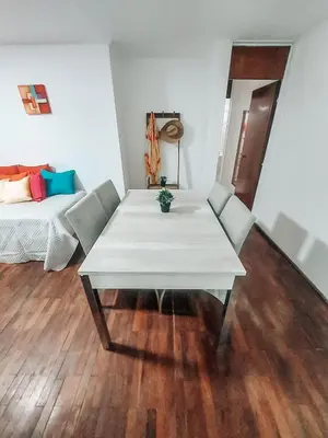 a white table and chairs in a room with a bed at Departamento en NUEVA CÓRDOBA a cuadras de Plaza España y del consulado español in Cordoba