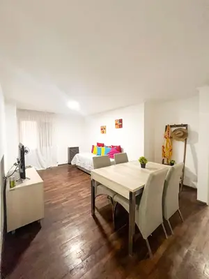 a living room with a table and a bed at Departamento en NUEVA CÓRDOBA a cuadras de Plaza España y del consulado español in Cordoba
