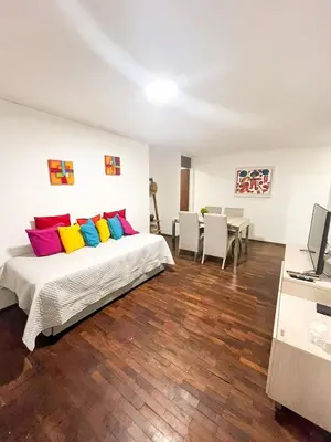 a bedroom with a bed with colorful pillows at Departamento en NUEVA CÓRDOBA a cuadras de Plaza España y del consulado español in Cordoba