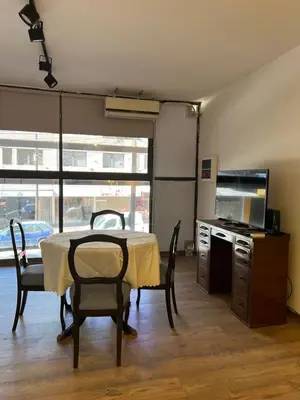 a dining room with a table and chairs and a television at Departamento Carlos Paz in Villa Carlos Paz